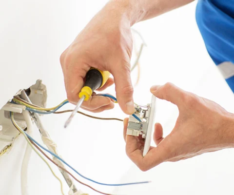 Hands working on electrical components